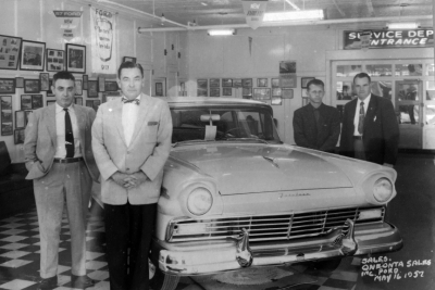 Showroom with salesman, left to right: Gerald Levine, Ed Deery, Walt Mindich, unknown. (c.1957)